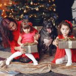 Beautiful woman in a red dress. Family at home. Mother with daughter. People with a dog.